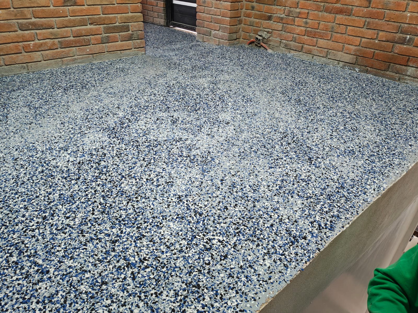 10. Piso cubierto completamente. El área queda totalmente cubierta con hojuelas decorativas, lista para retirar el exceso y preparar el sellado.
